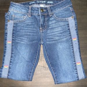 Girls Cat & Jack Jeans with rainbow hearts down the sides.
